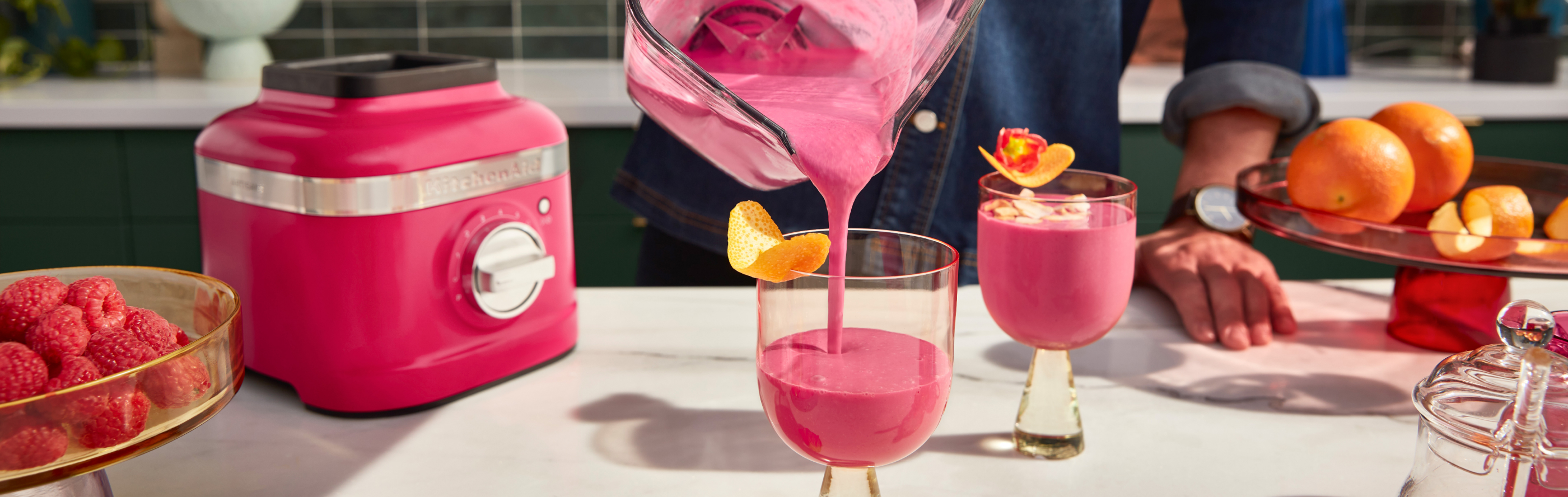 Frozen pink cocktails being poured from blender to glass