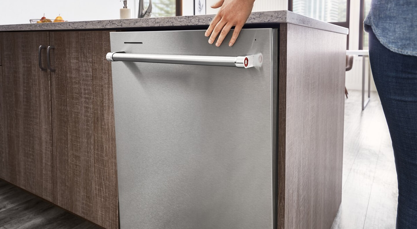 Person closing a top control dishwasher