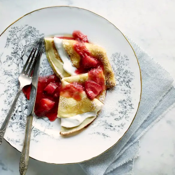 Delicate crepes with strawberries and rhubarb on top.