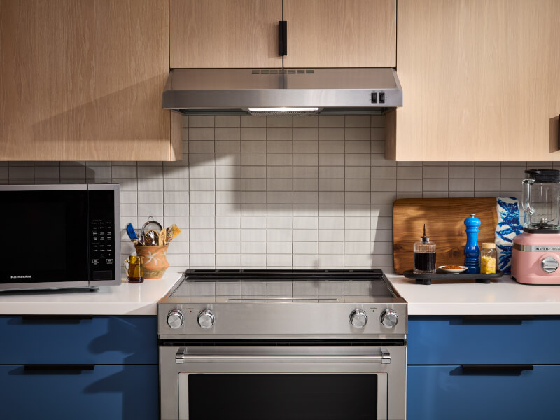 Electric range and under-cabinet range hood in a bright kitchen