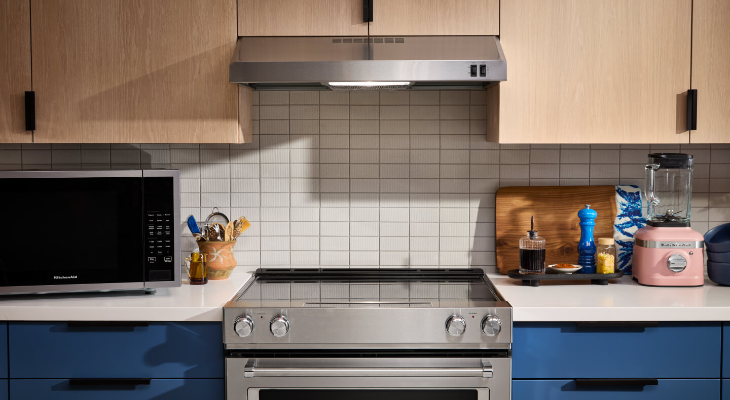 Electric range and under-cabinet range hood in a bright kitchen