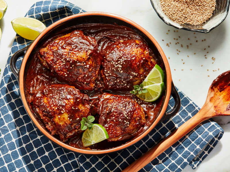 Chicken sitting in barbeque sauce marinade surrounded by lime wedges Chicken sitting in barbeque sauce marinade surrounded by lime wedges