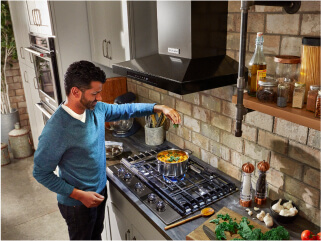 A person using their cooktop in a kitchen