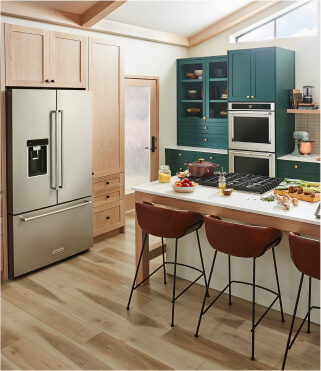 A KitchenAid® refrigerator in a kitchen with teal cabinets