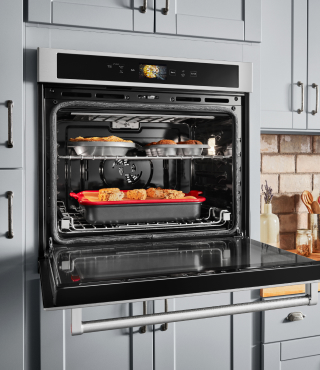 Trays of food roasting in a convection oven