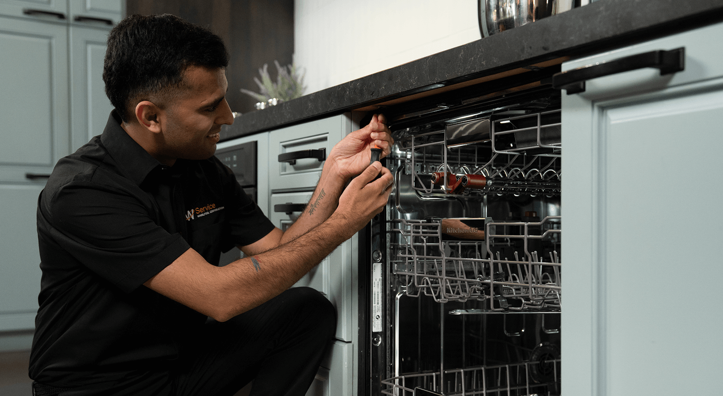 A technician works on a dishwasher A technician works on a dishwasher