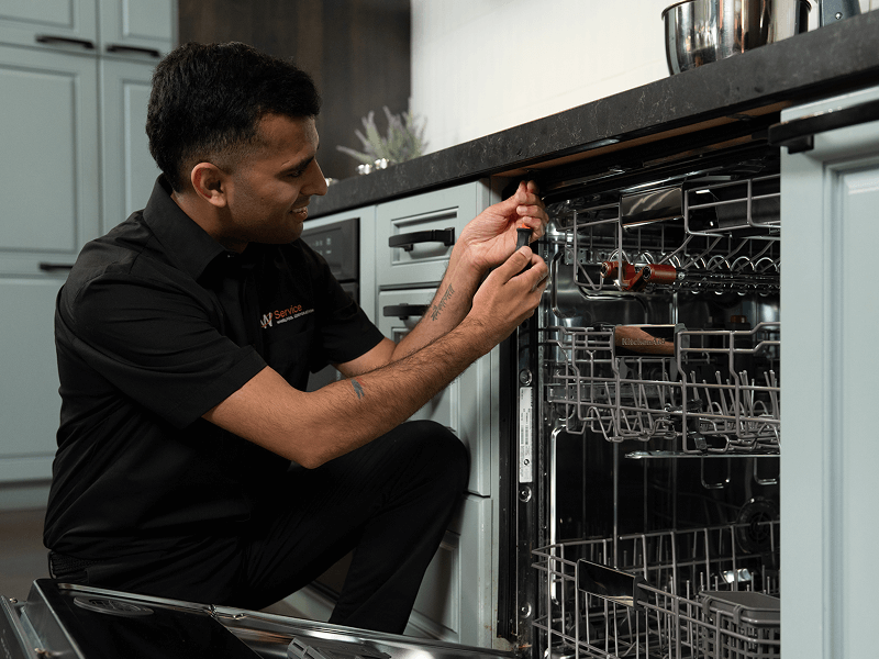 A technician works on a dishwasher A technician works on a dishwasher