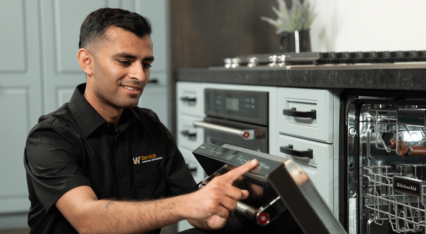 A technician works on a dishwasher A technician works on a dishwasher