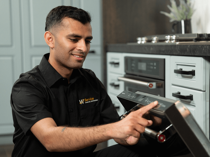 A technician works on a dishwasher A technician works on a dishwasher