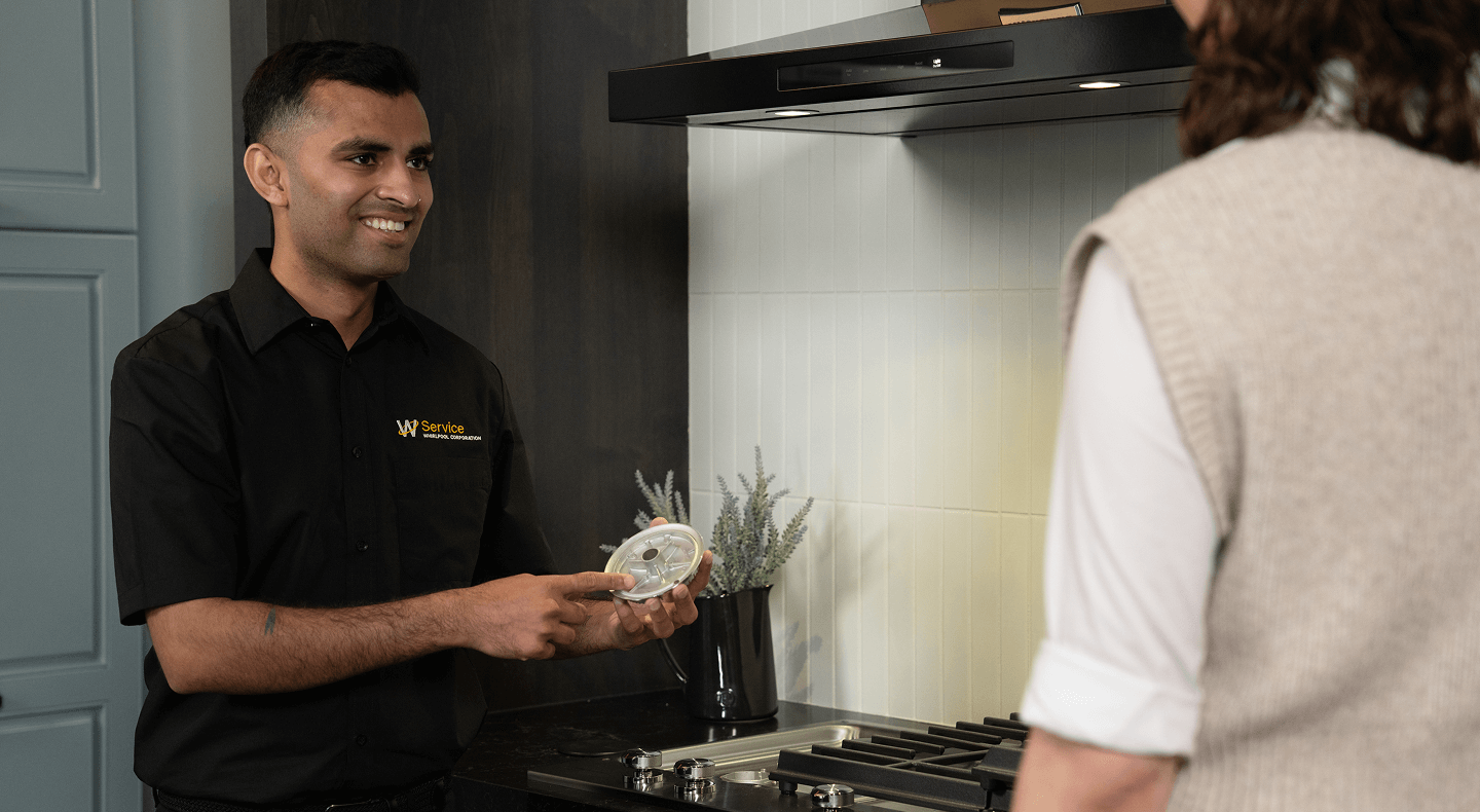 A technician helps someone with their cooktop A technician helps someone with their cooktop