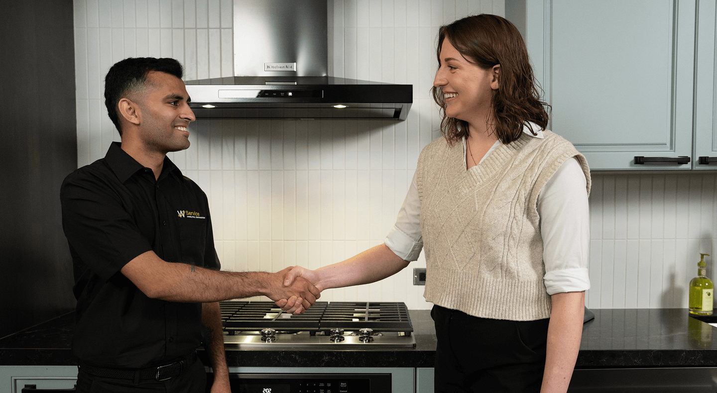 A technician helps a person in their kitchen A technician helps a person in their kitchen