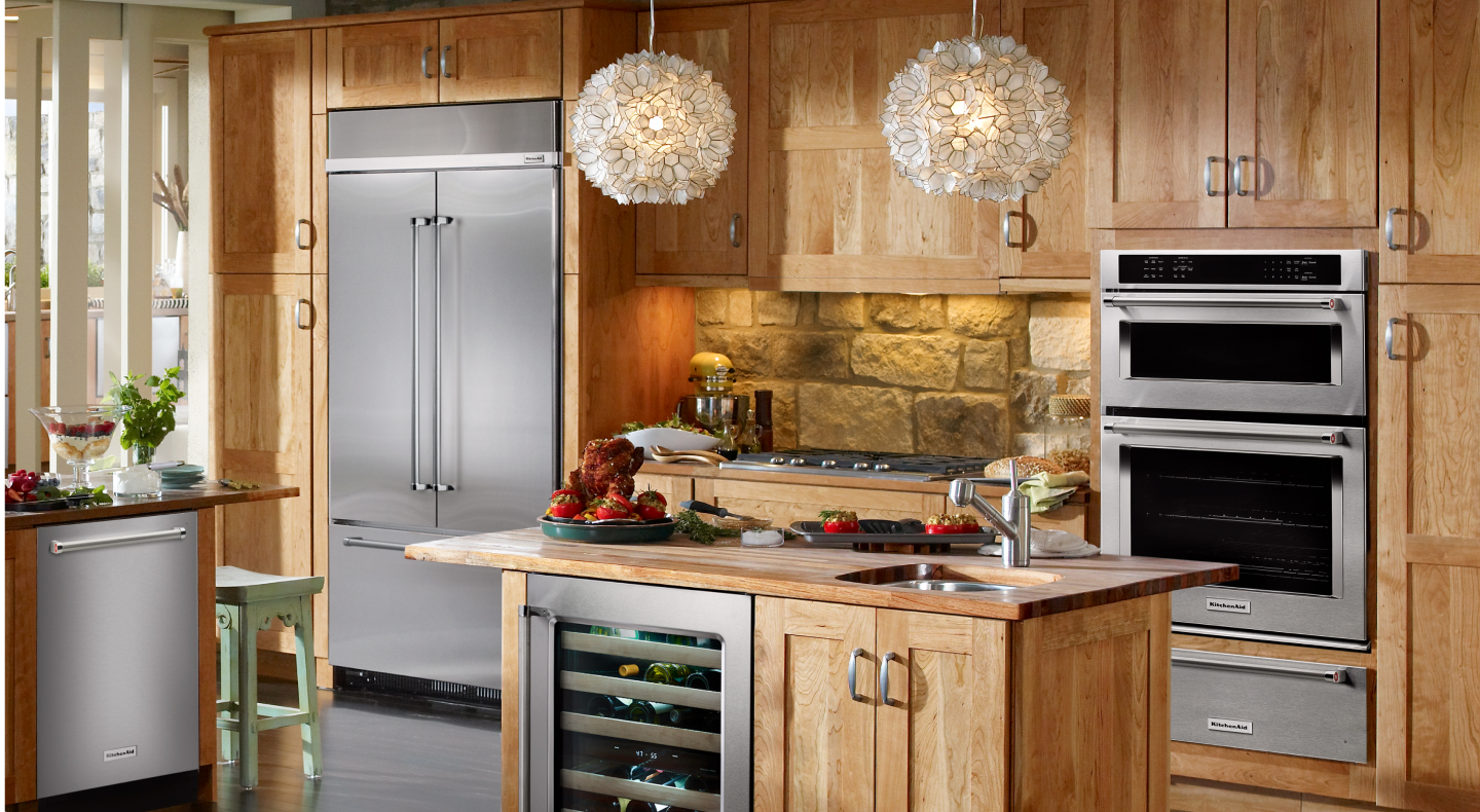 Stainless steel french door refrigerator built into a rustic wooden kitchen Stainless steel french door refrigerator built into a rustic wooden kitchen