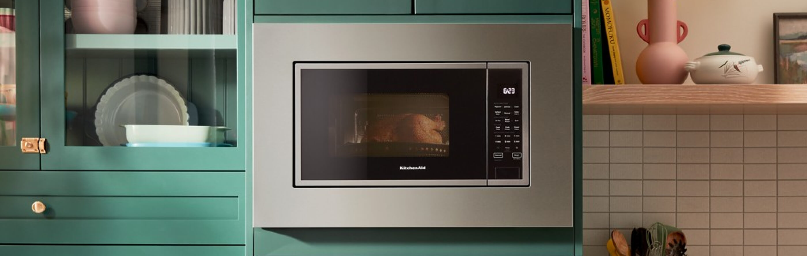 A built-in KitchenAid® microwave surrounded by teal cabinetry