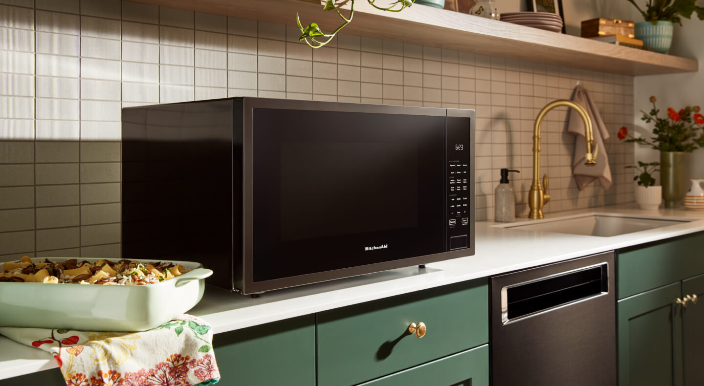 KitchenAid® countertop microwave above green cabinetry