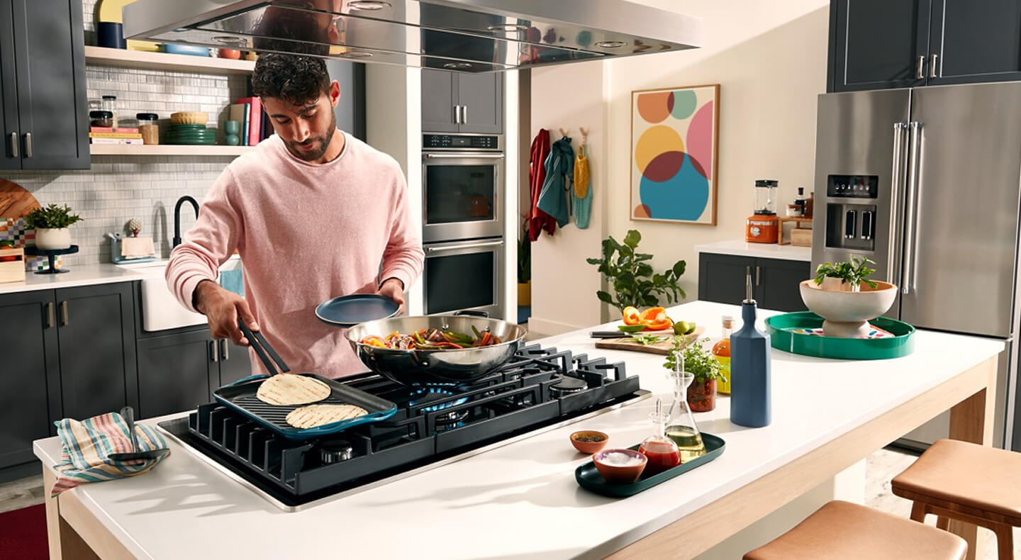 Person cooking on the griddle attachment of a gas stovetop Person cooking on the griddle attachment of a gas stovetop