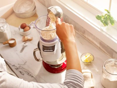 Person adding flour to the KitchenAid® Sifter + Scale attachment