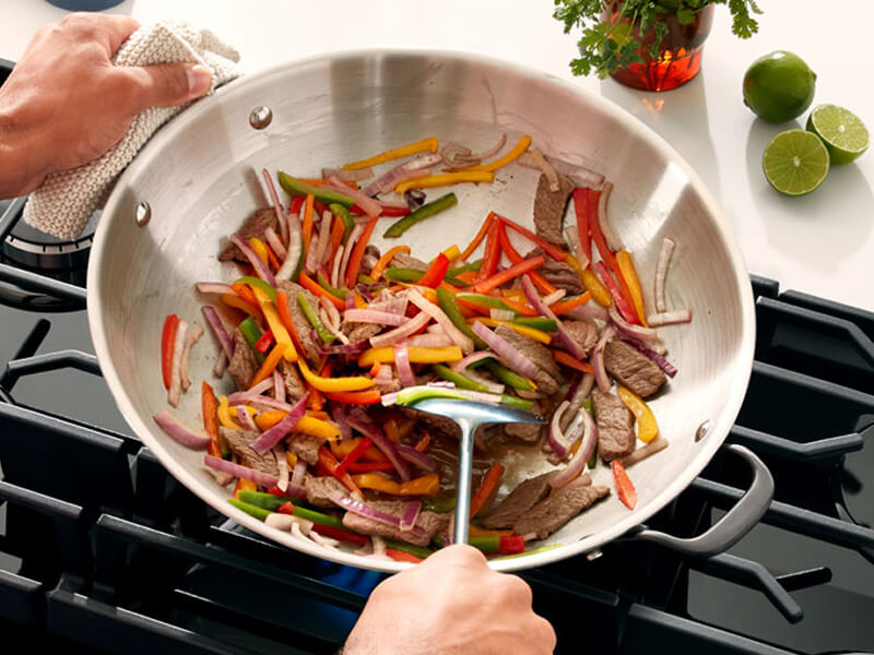 Someone cooking veggies in a pan