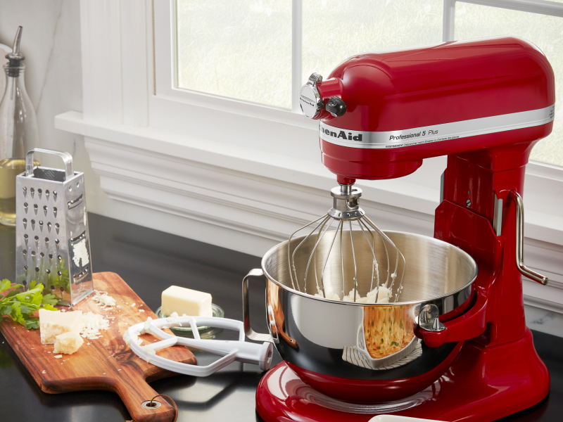 Red KitchenAid® stand mixer next to grated cheese and butter Red KitchenAid® stand mixer next to grated cheese and butter