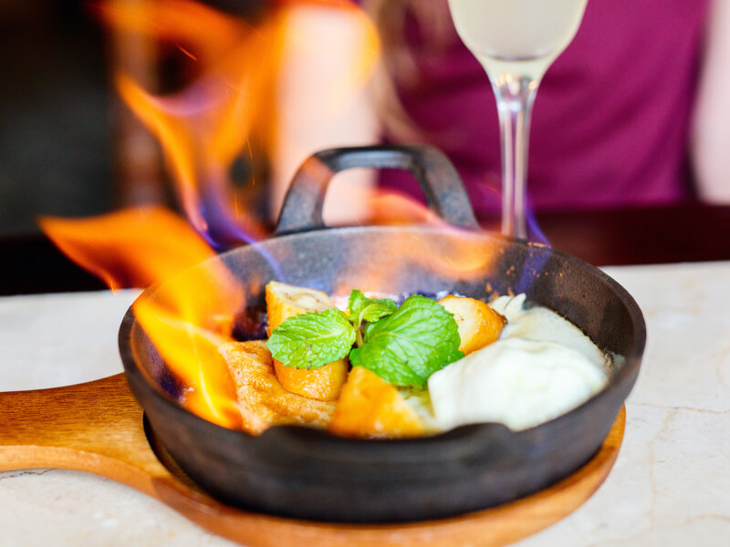 Skillet with food being flambéed
