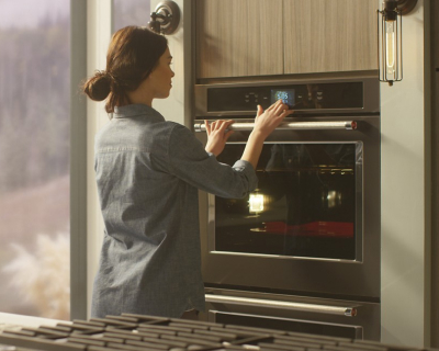Person selecting settings on a double wall oven