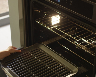An opened oven revealing the interior light