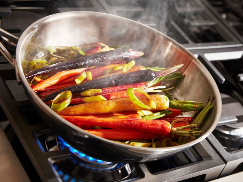Carrots cooking in a pan on a cooktop