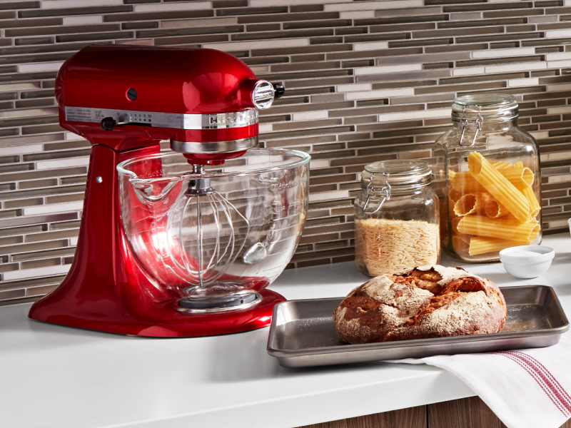 A loaf of bread next to a red KitchenAid® stand mixer with flat beater accessory A loaf of bread next to a red KitchenAid® stand mixer with flat beater accessory