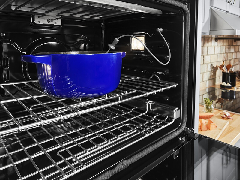 Blue casserole dish in an oven with a temperature monitor in it Blue casserole dish in an oven with a temperature monitor in it