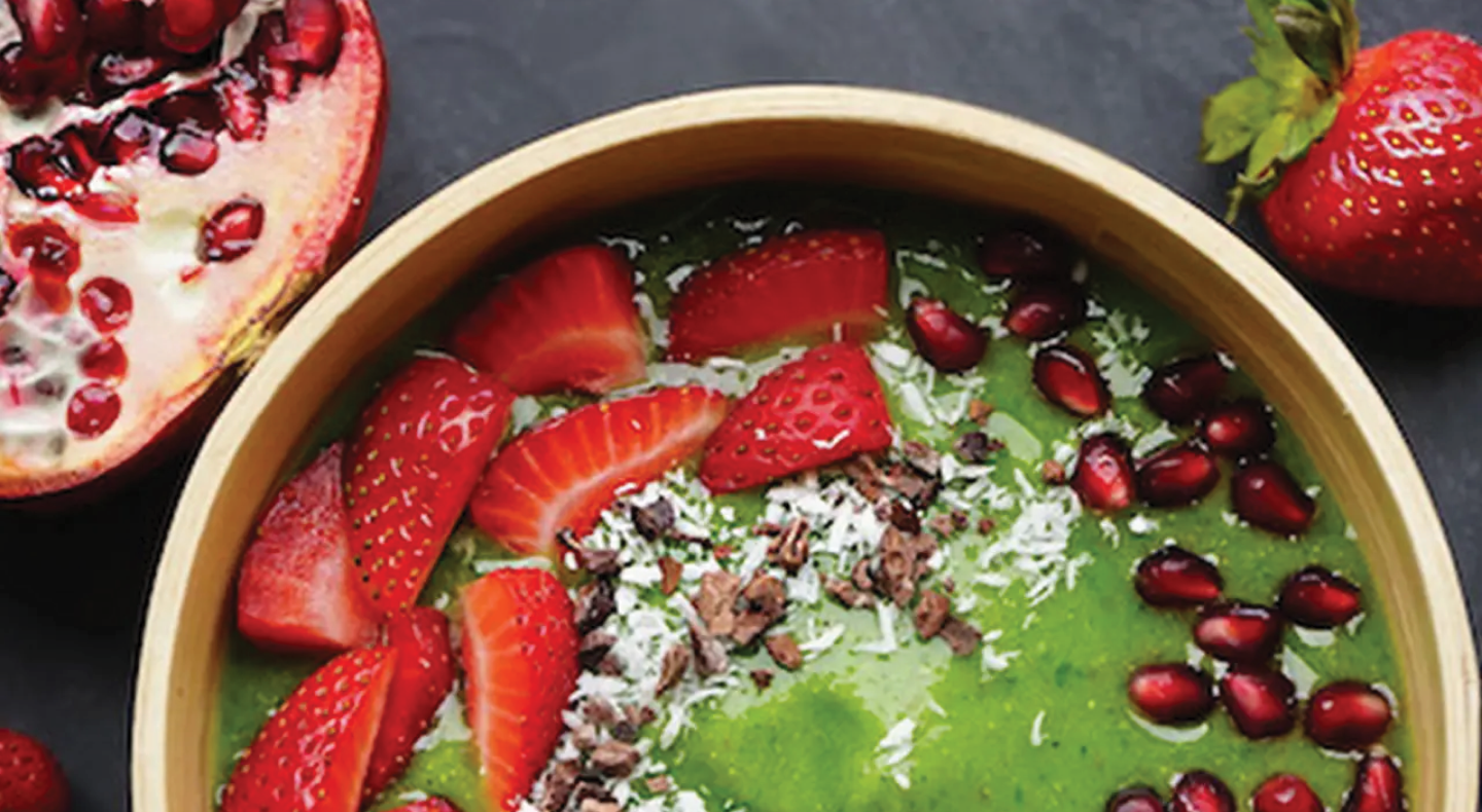 Close-up of green smoothie bowl with strawberries and pomegranate seeds Close-up of green smoothie bowl with strawberries and pomegranate seeds