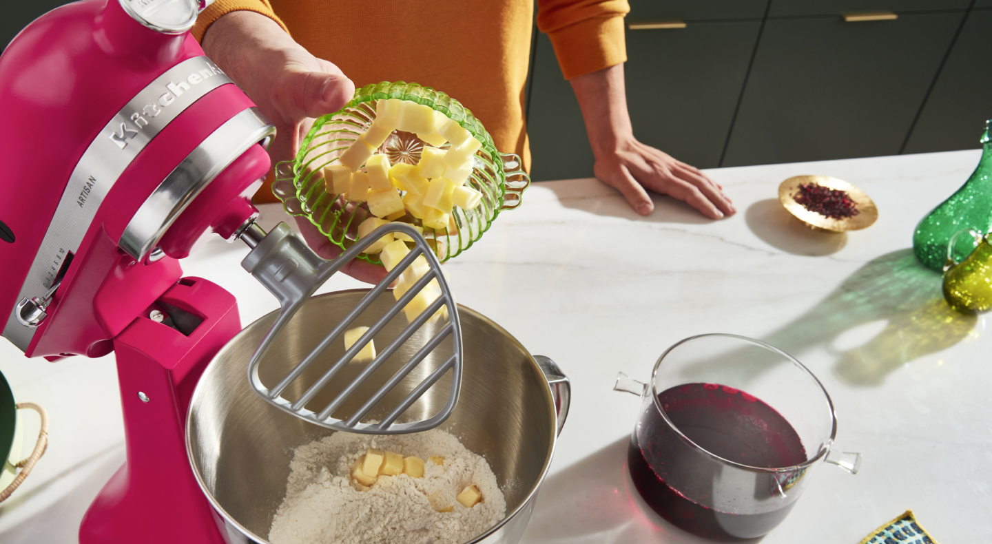 Person adding butter into a KitchenAid® stand mixer Person adding butter into a KitchenAid® stand mixer
