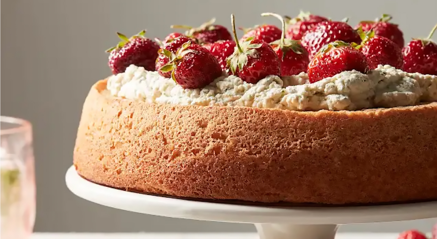 A frosted cake topped with fresh strawberries.