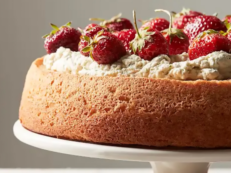 A frosted cake topped with fresh strawberries.