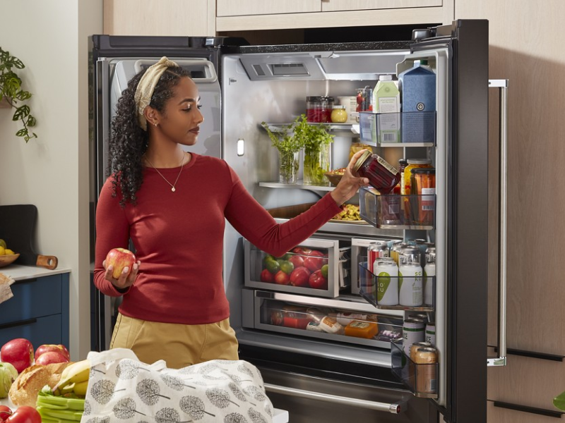 Person putting food in a French-door refrigerator Person putting food in a French-door refrigerator