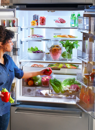 Person placing produce inside a French door refrigerator