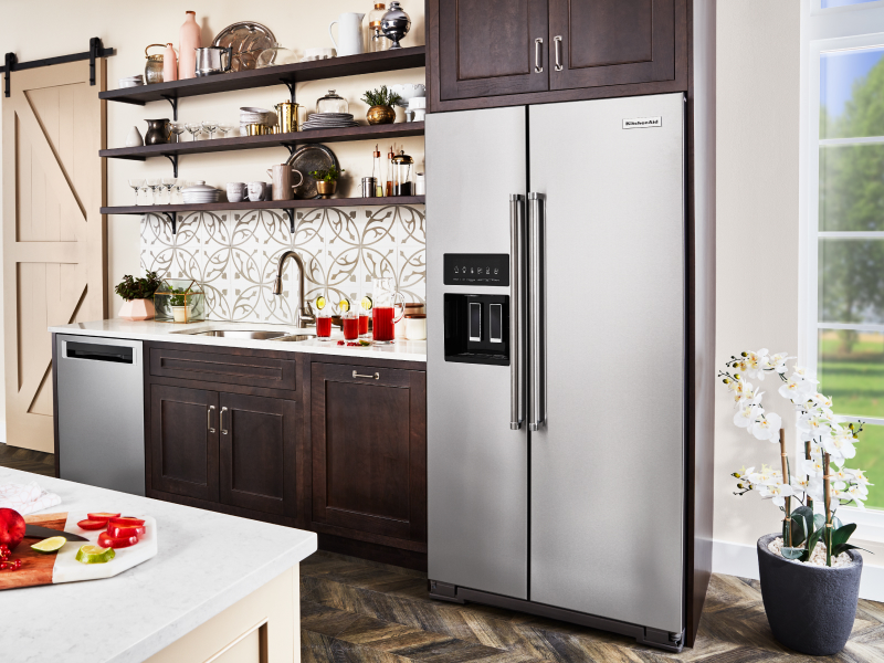 Stainless steel, side-by-side KitchenAid® refrigerator in brown cabinetry Stainless steel, side-by-side KitchenAid® refrigerator in brown cabinetry