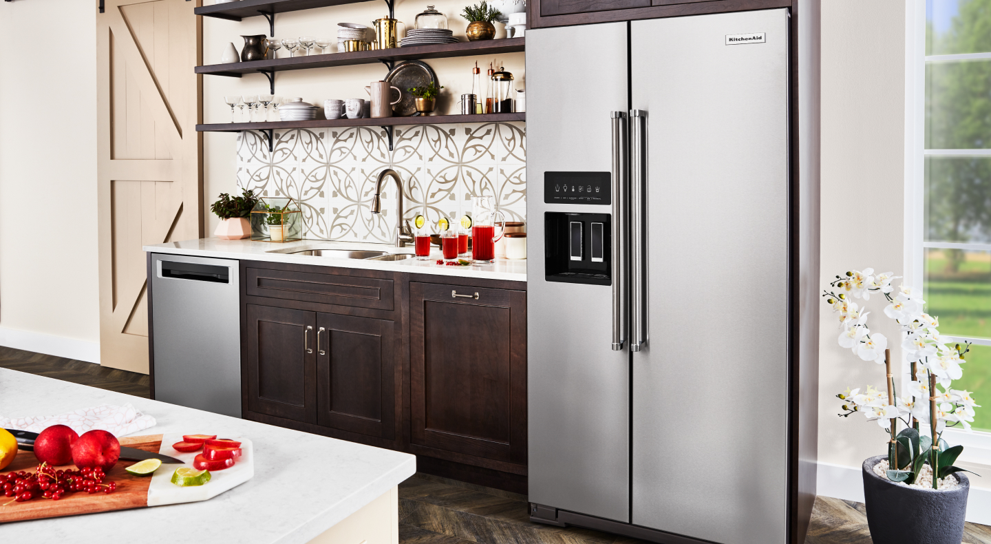 Stainless steel, side-by-side KitchenAid® refrigerator in brown cabinetry Stainless steel, side-by-side KitchenAid® refrigerator in brown cabinetry