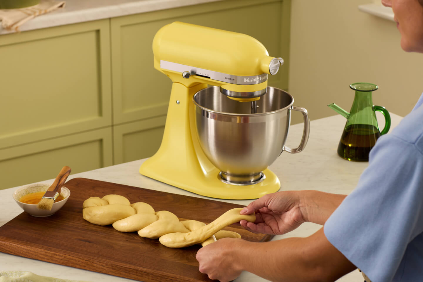 A person braiding dough in front of the Butter stand mixer.