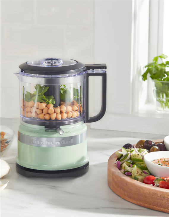 A KitchenAid Food Chopper behind a fresh salad.