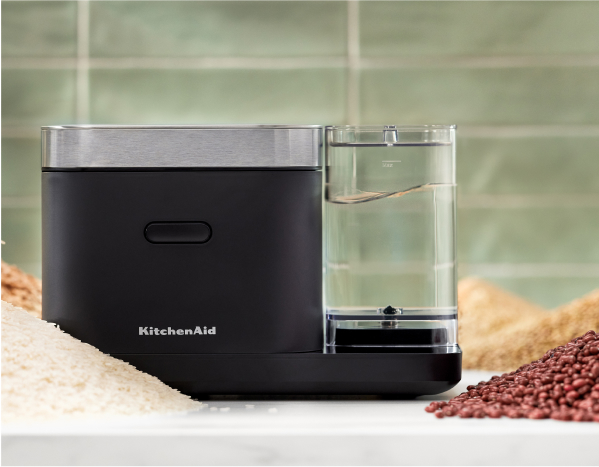 A KitchenAid Grain and Rice Cooker against a green tile backsplash