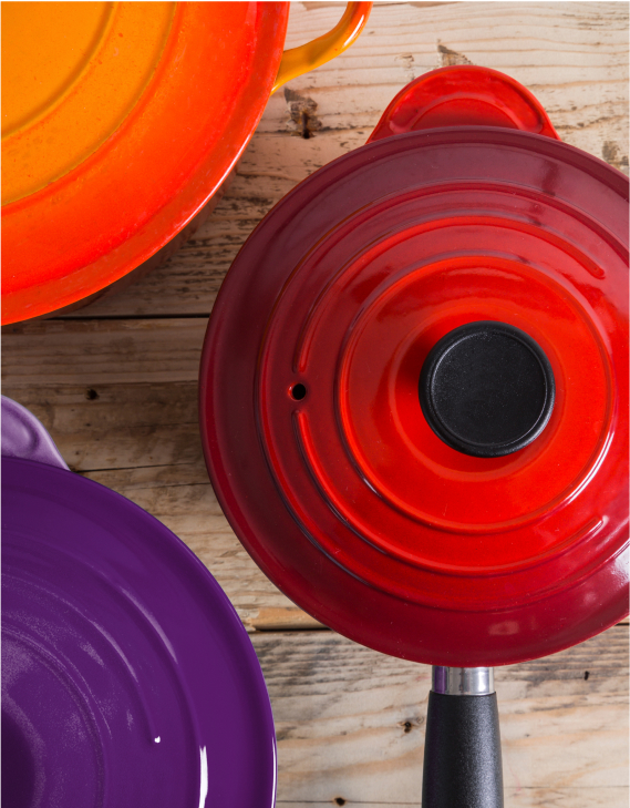 A set of three sauce pans in rich jewel-toned red, orange and purple