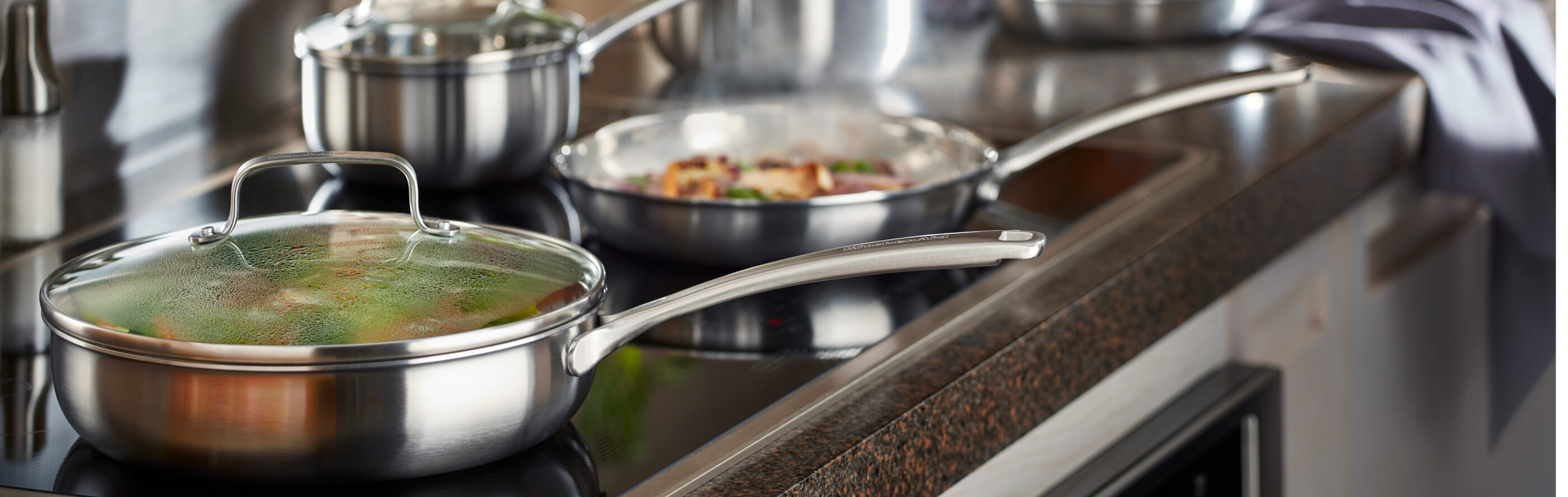 A stainless steel skillet on a KitchenAid brand induction cooktop
