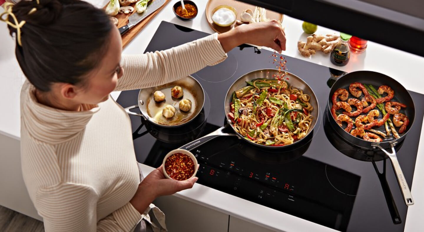 Person cooking on an electric cooktop Person cooking on an electric cooktop