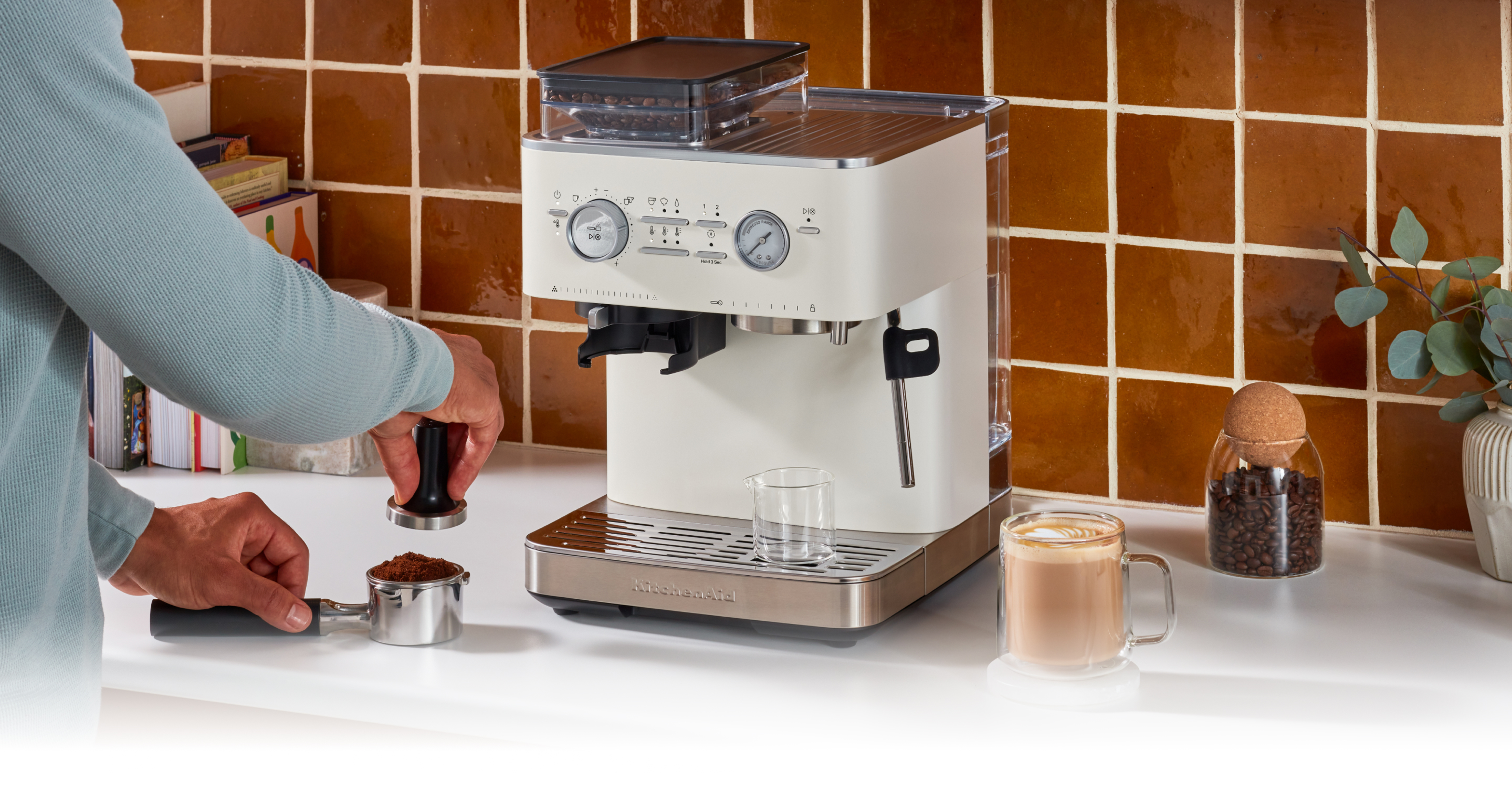 A person tamping down ground coffee beans.