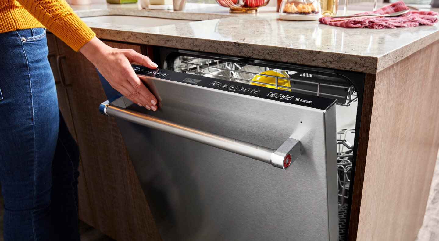 Title Needed A hand closing a top control built-in dishwasher with a towel bar handle