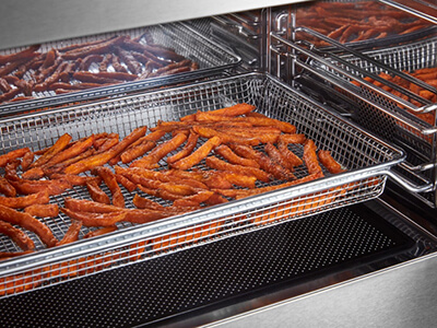 Sweet potato fries in an air fryer basket Sweet potato fries in an air fryer basket