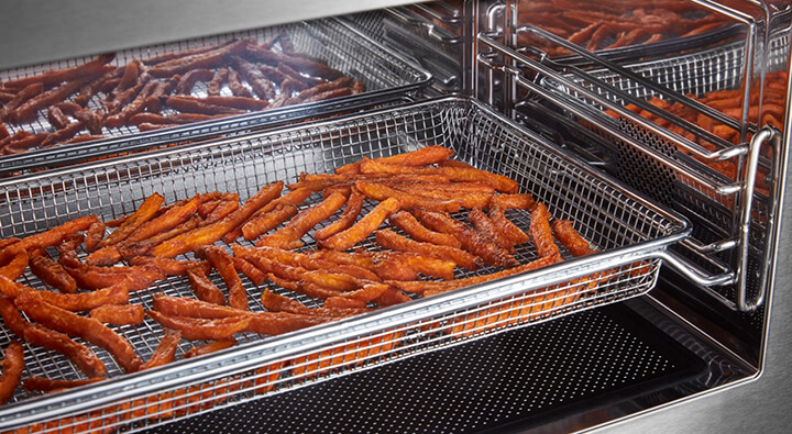 Sweet potato fries in an air fryer basket Sweet potato fries in an air fryer basket
