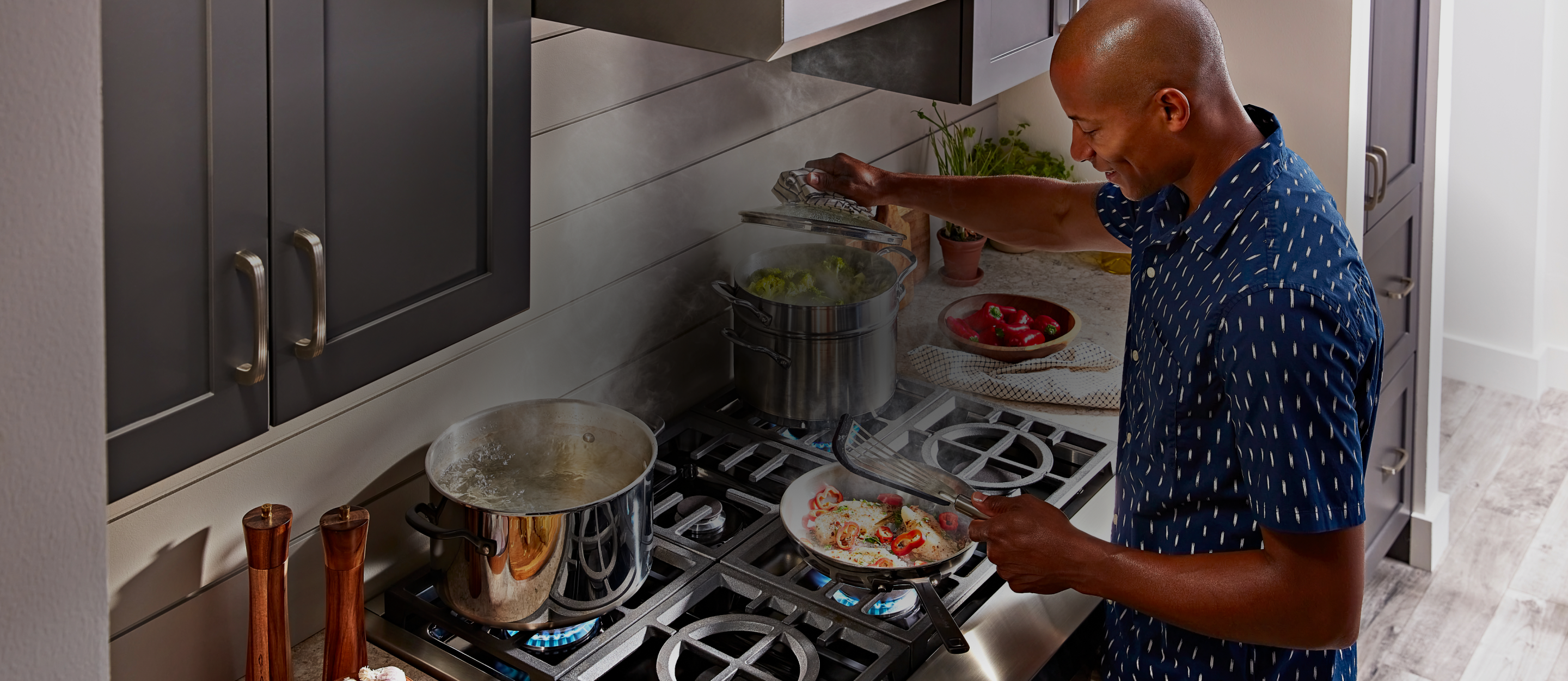 Person cooking meal on a KitchenAid brand cooktop