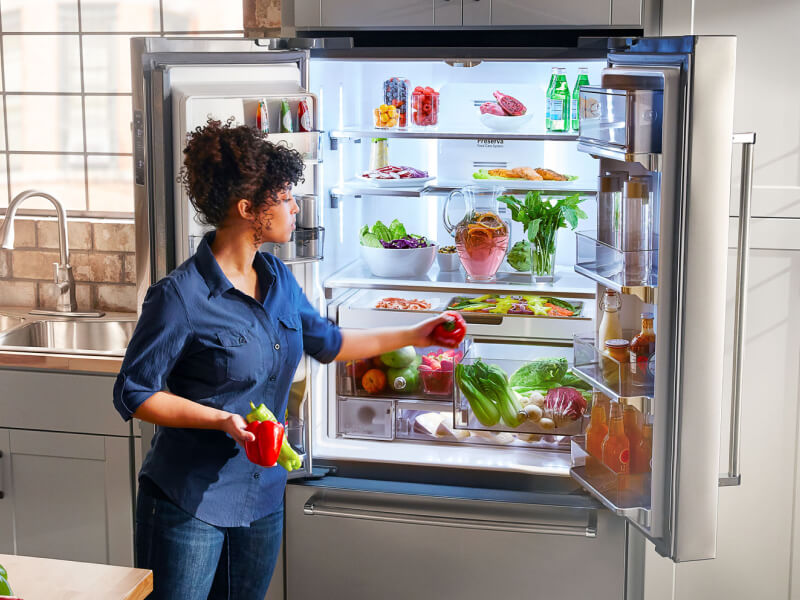 A person putting away fresh vegetables in a KitchenAid® french door refrigerator A person putting away fresh vegetables in a KitchenAid® french door refrigerator