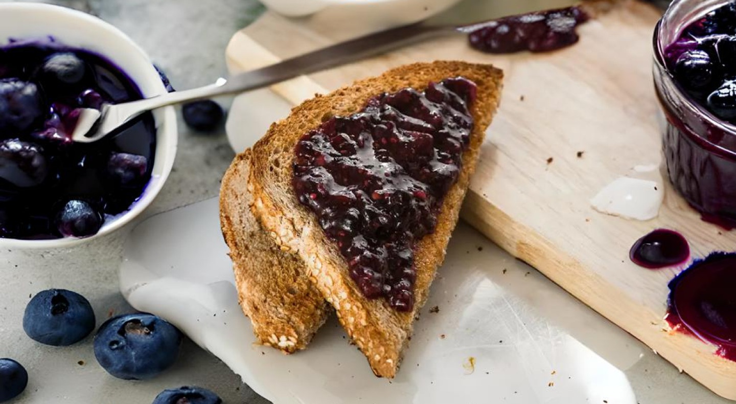 A slice of toast spread with vegan jam A slice of toast spread with vegan jam