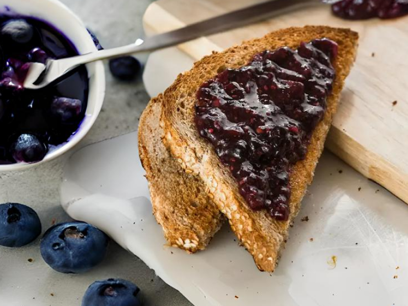 A slice of toast spread with vegan jam A slice of toast spread with vegan jam